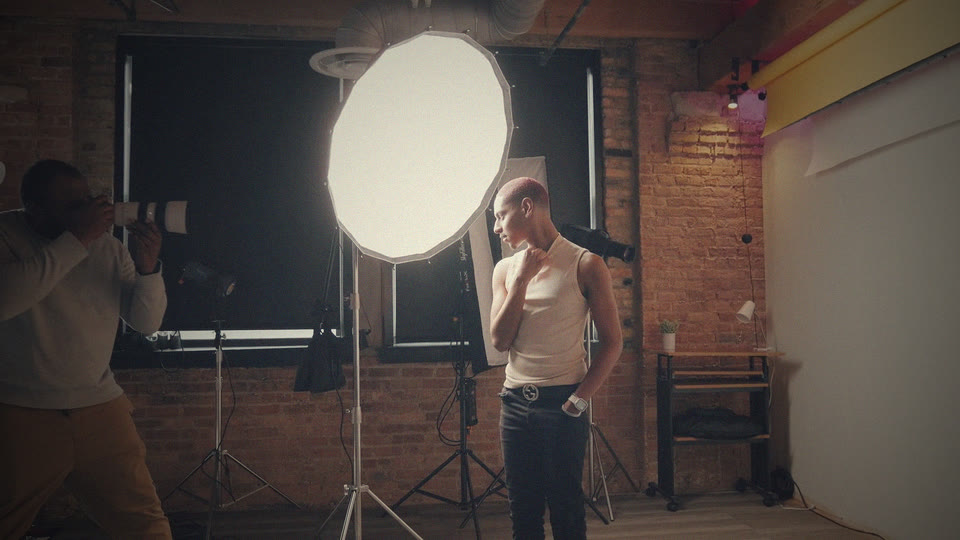 Photographer shooting a portrait in a studio with a softbox